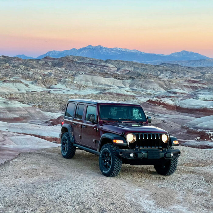 dark red jeep sitting on a bentonite hill