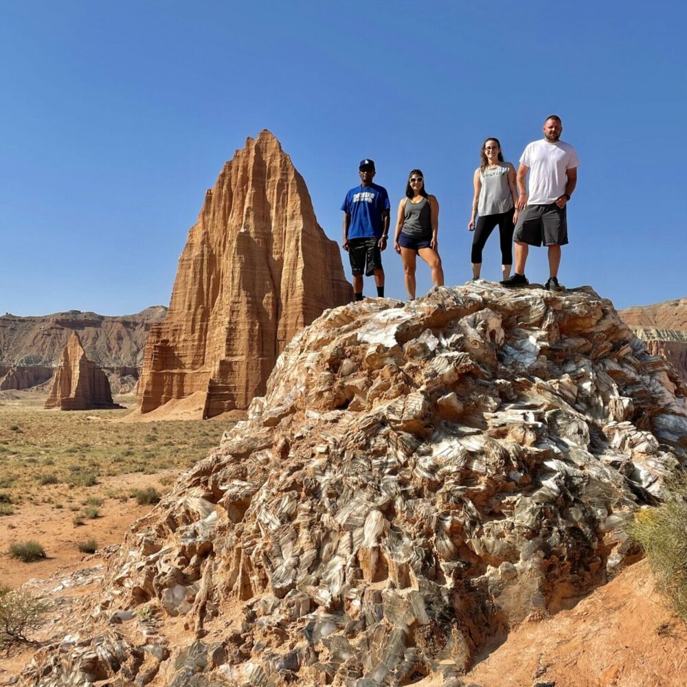four adults standing on top of gypsum crystal mound known as the glass mountain, inside the cathedral valley, capitol reef national park
